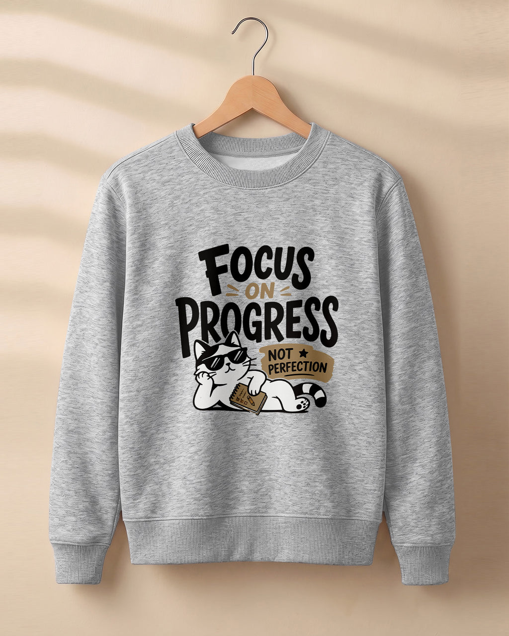 Motivational graphic sweatshirt featuring relaxed cat wearing sunglasses artwork with Focus on Progress, Not Perfection quote printed on cotton fabric