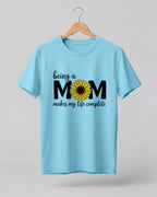 Mom quote graphic half sleeve t-shirt featuring “Being a MOM makes my life complete” with sunflower design