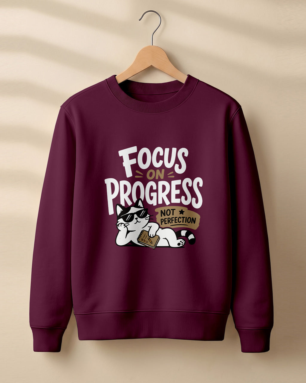 Motivational graphic sweatshirt featuring relaxed cat wearing sunglasses artwork with Focus on Progress, Not Perfection quote printed on cotton fabric