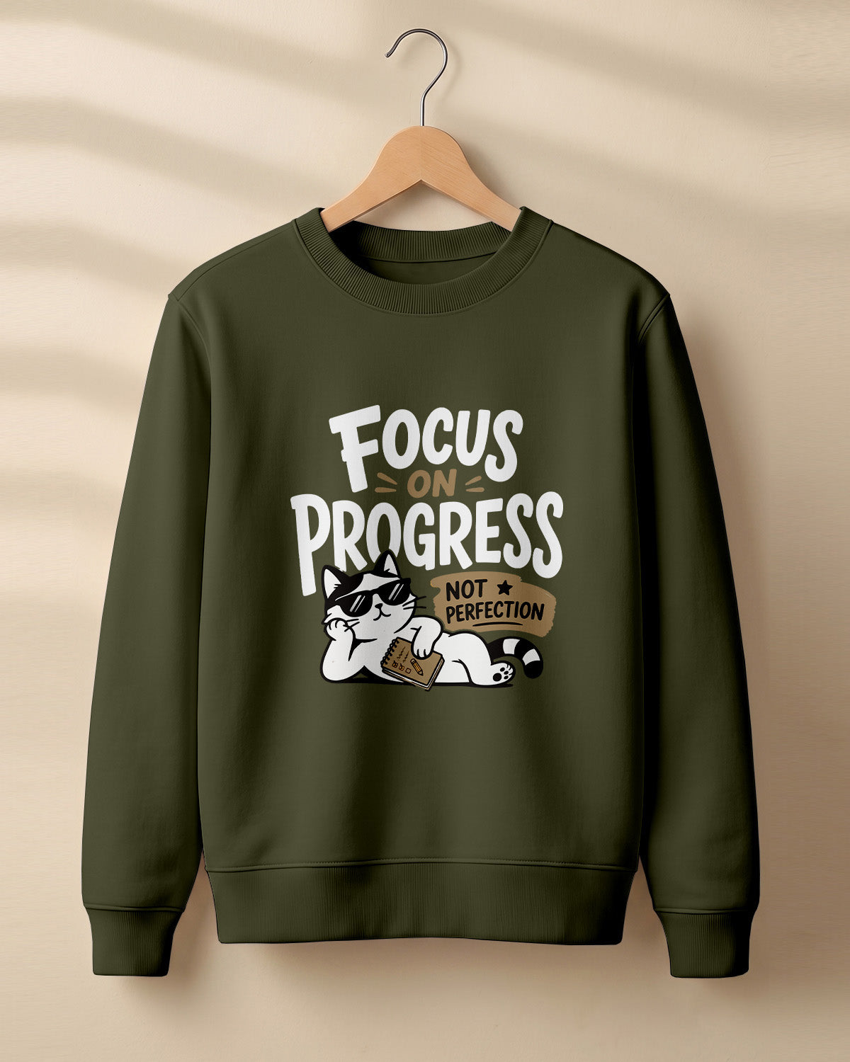Motivational graphic sweatshirt featuring relaxed cat wearing sunglasses artwork with Focus on Progress, Not Perfection quote printed on cotton fabric