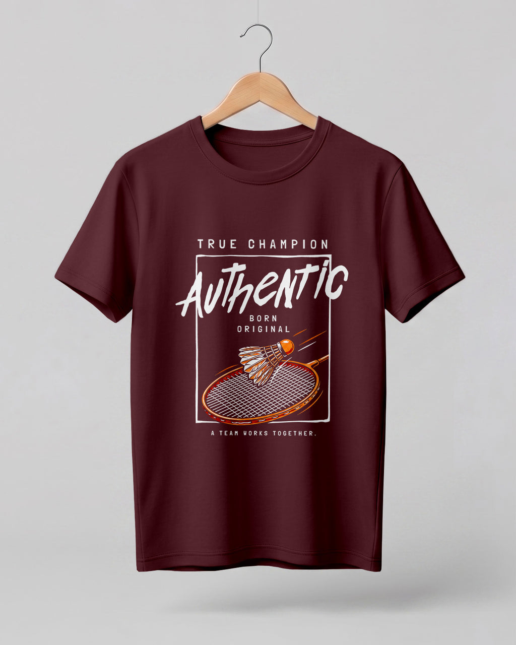 Motivational sports graphic half sleeve t-shirt featuring badminton racket and shuttlecock with “True Champion Authentic Born Original A Team Works Together” typography design on premium cotton fabric.