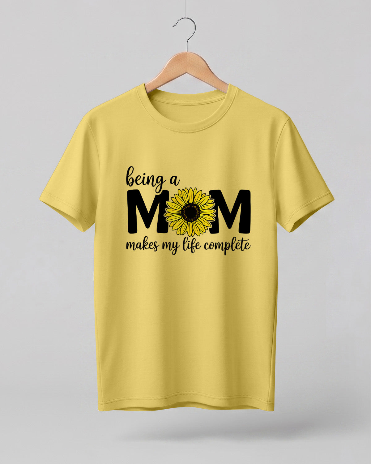 Mom quote graphic half sleeve t-shirt featuring “Being a MOM makes my life complete” with sunflower design
