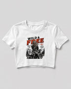 Xenovaurban crop top featuring a woman riding a motorcycle against a scenic mountain backdrop with Wild & Free typography