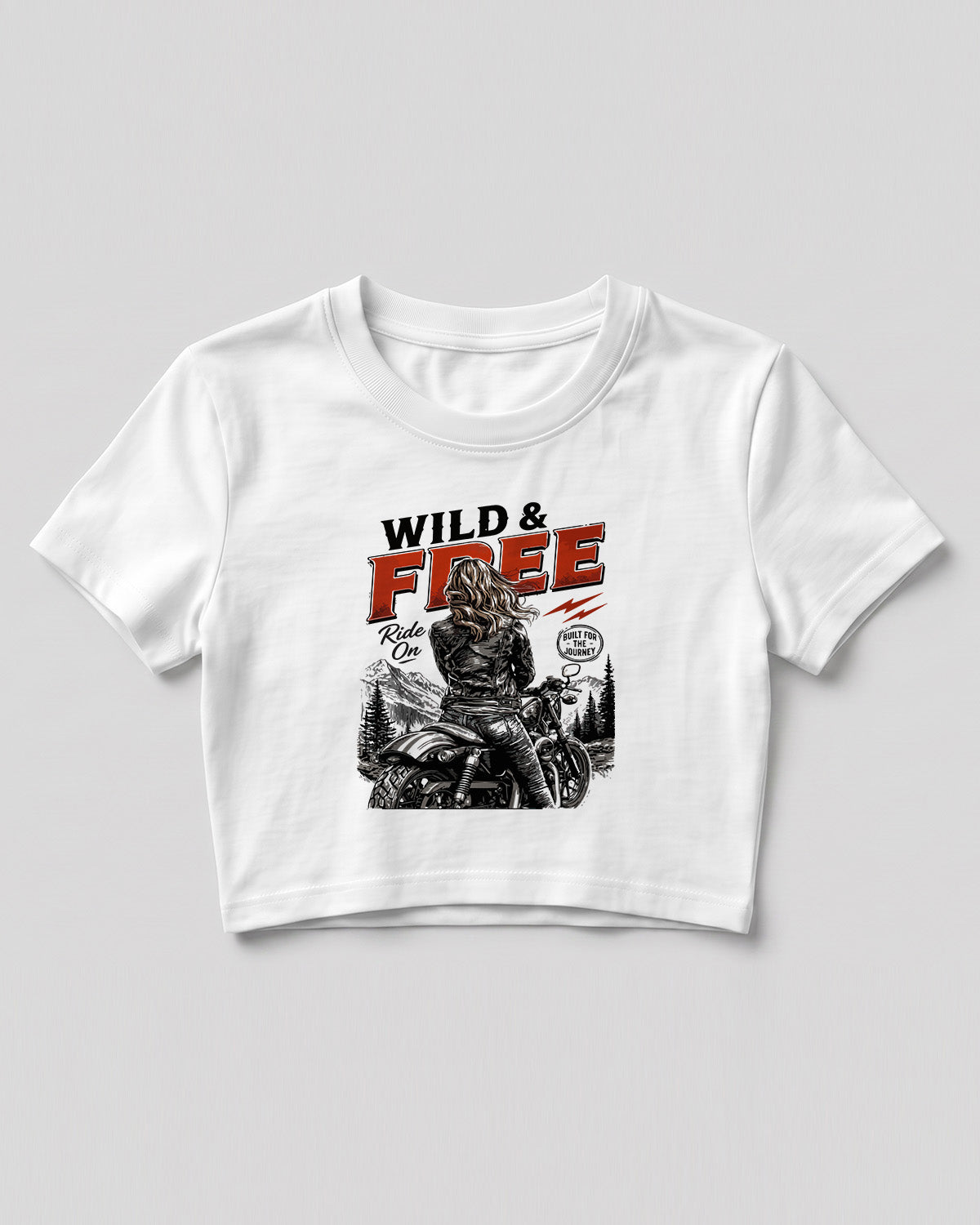 Xenovaurban crop top featuring a woman riding a motorcycle against a scenic mountain backdrop with Wild & Free typography