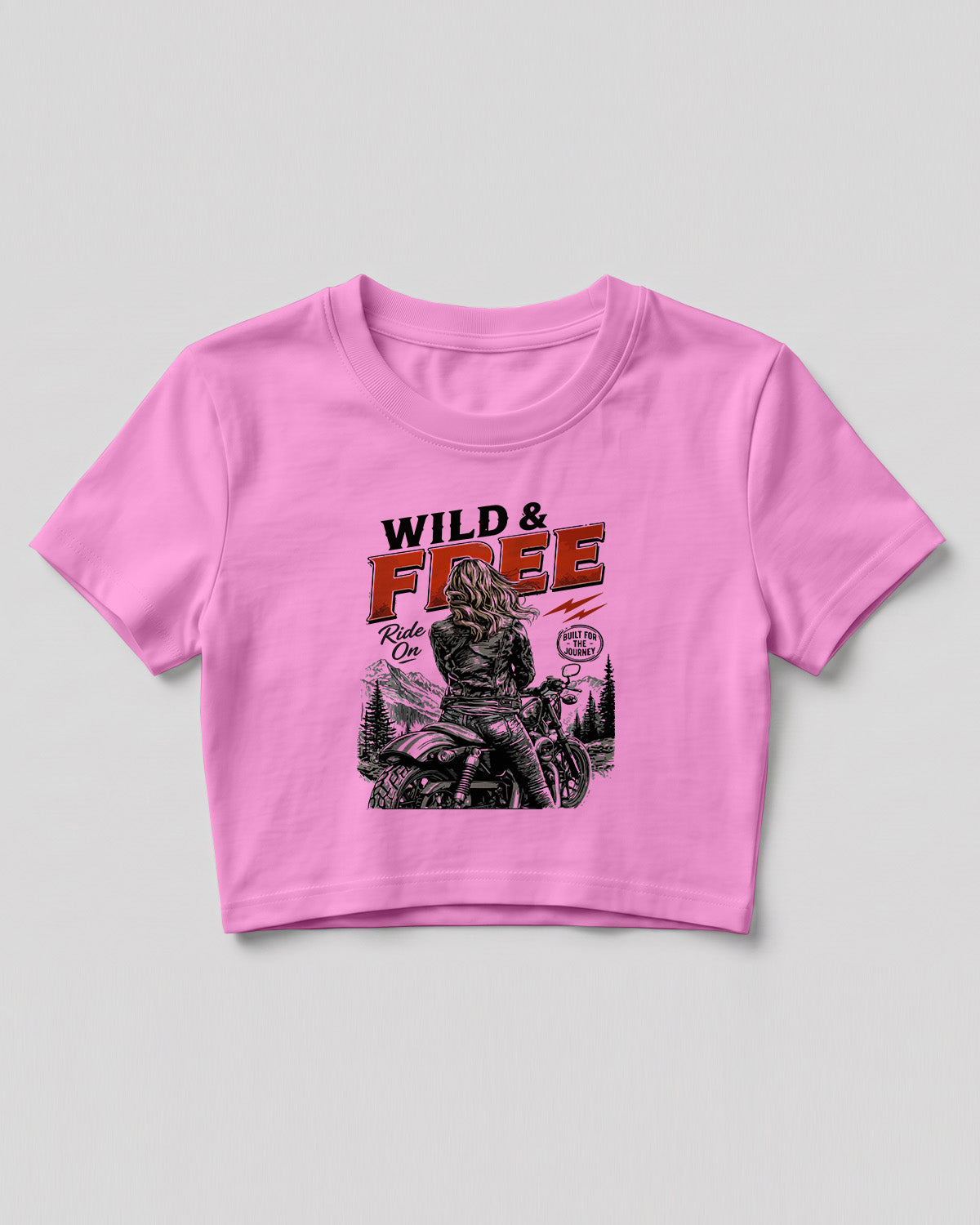 Xenovaurban crop top featuring a woman riding a motorcycle against a scenic mountain backdrop with Wild & Free typography