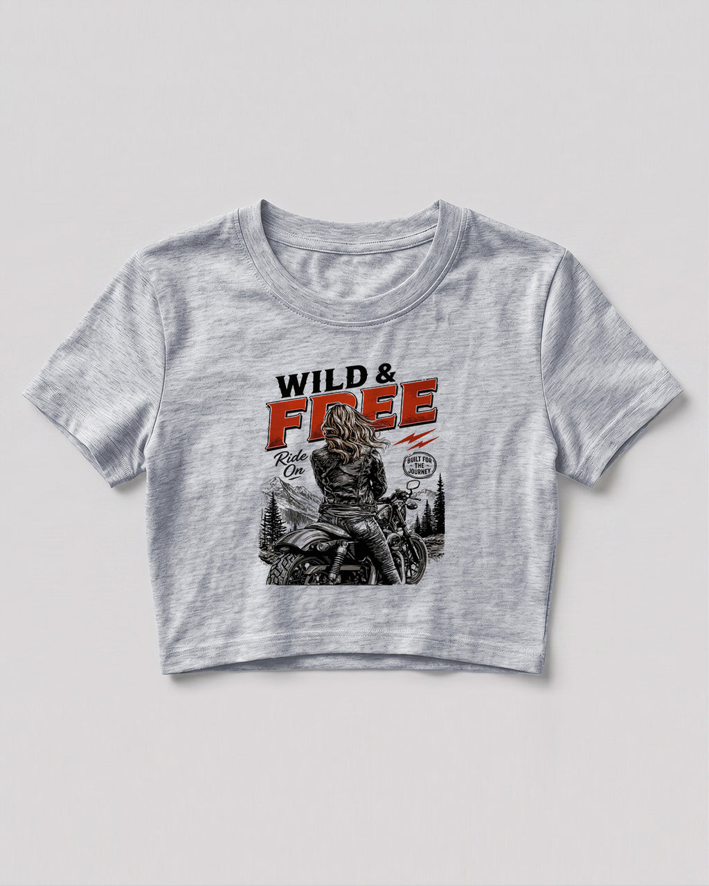 Xenovaurban crop top featuring a woman riding a motorcycle against a scenic mountain backdrop with Wild & Free typography