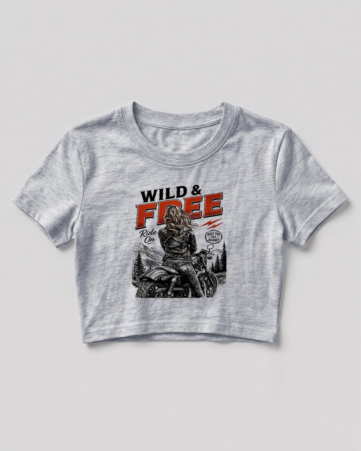 Xenovaurban crop top featuring a woman riding a motorcycle against a scenic mountain backdrop with Wild & Free typography