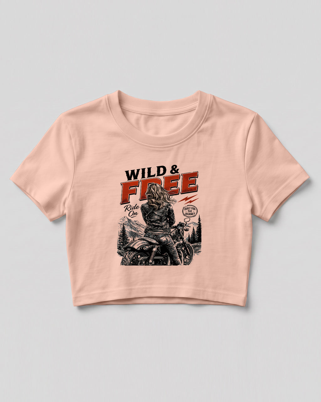 Xenovaurban crop top featuring a woman riding a motorcycle against a scenic mountain backdrop with Wild & Free typography