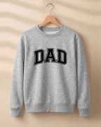 Xenovaurban graphic sweatshirt featuring bold varsity-style “DAD” typography.