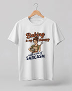 Foodie graphic half sleeve t-shirt featuring cartoon baker illustration with “Baking Is My Therapy with a Side of Sarcasm” typography printed on premium cotton fabric.