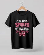 Funny husband quote graphic half sleeve t-shirt featuring “I'm Not Spoiled, My Husband Just Loves Me” with a pink bow design