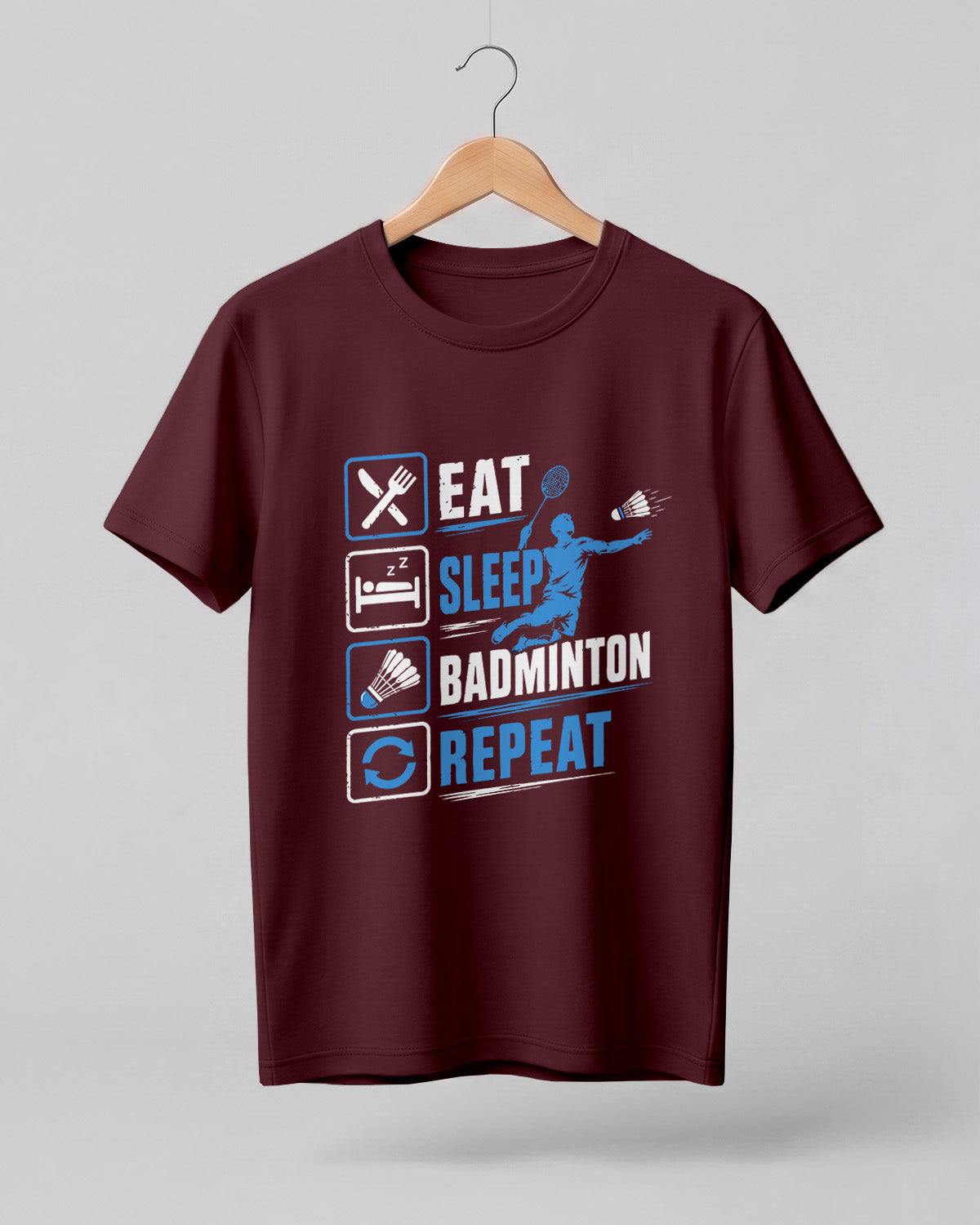 Motivational sports graphic half sleeve t-shirt featuring Eat Sleep Badminton Repeat typography with icons printed on premium cotton fabric.