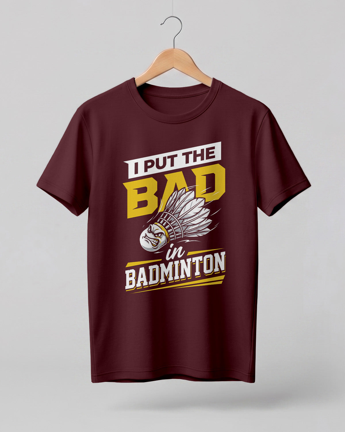 Humorous sports graphic half sleeve t-shirt featuring “I Put the Bad in Badminton” typography with shuttlecock illustration printed on premium cotton fabric.