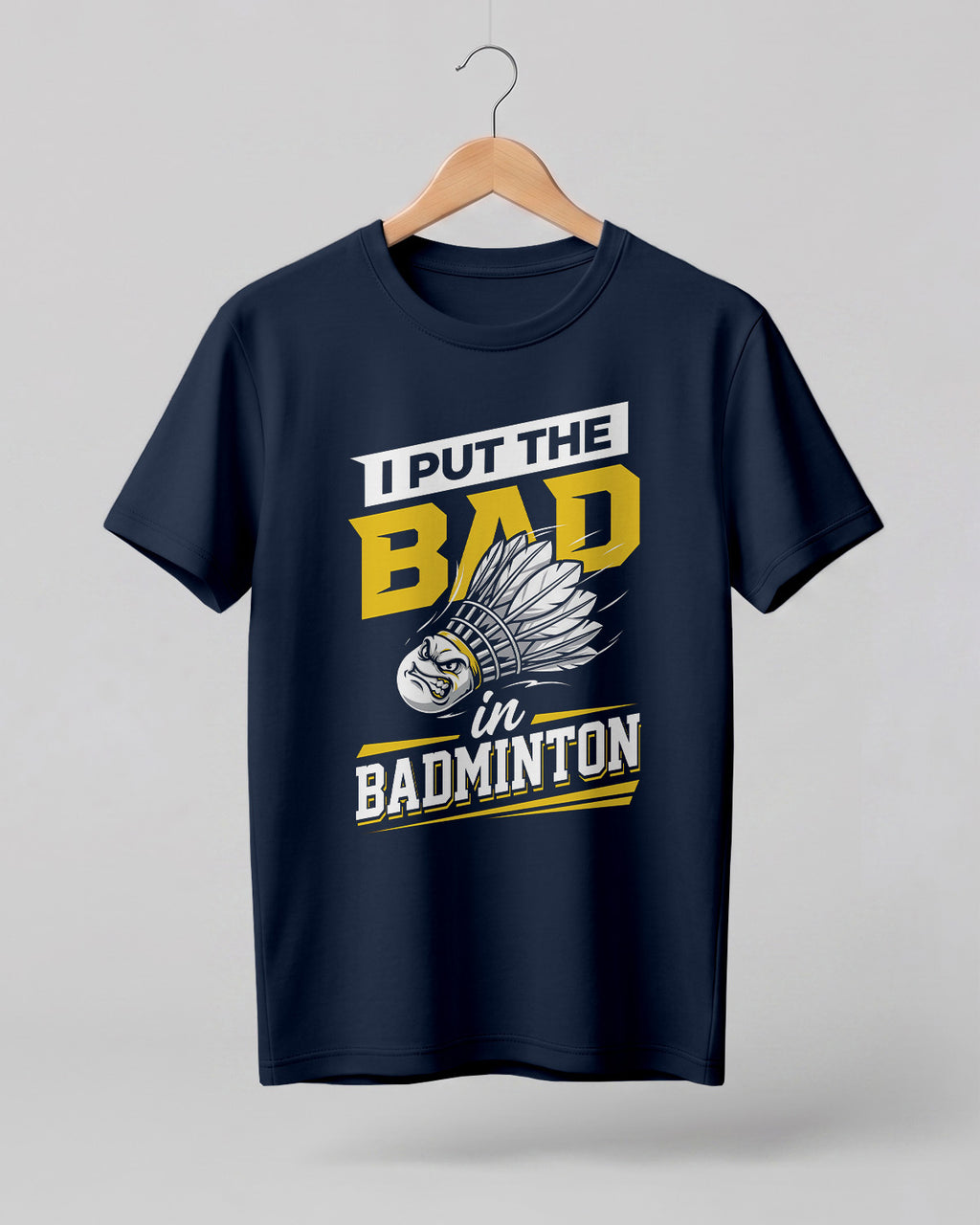 Humorous sports graphic half sleeve t-shirt featuring “I Put the Bad in Badminton” typography with shuttlecock illustration printed on premium cotton fabric.