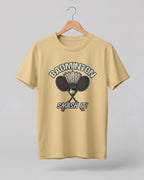 Motivational sports graphic half sleeve t-shirt featuring “Badminton Smash It!” typography with crossed racket and shuttlecock design printed on premium cotton fabric.