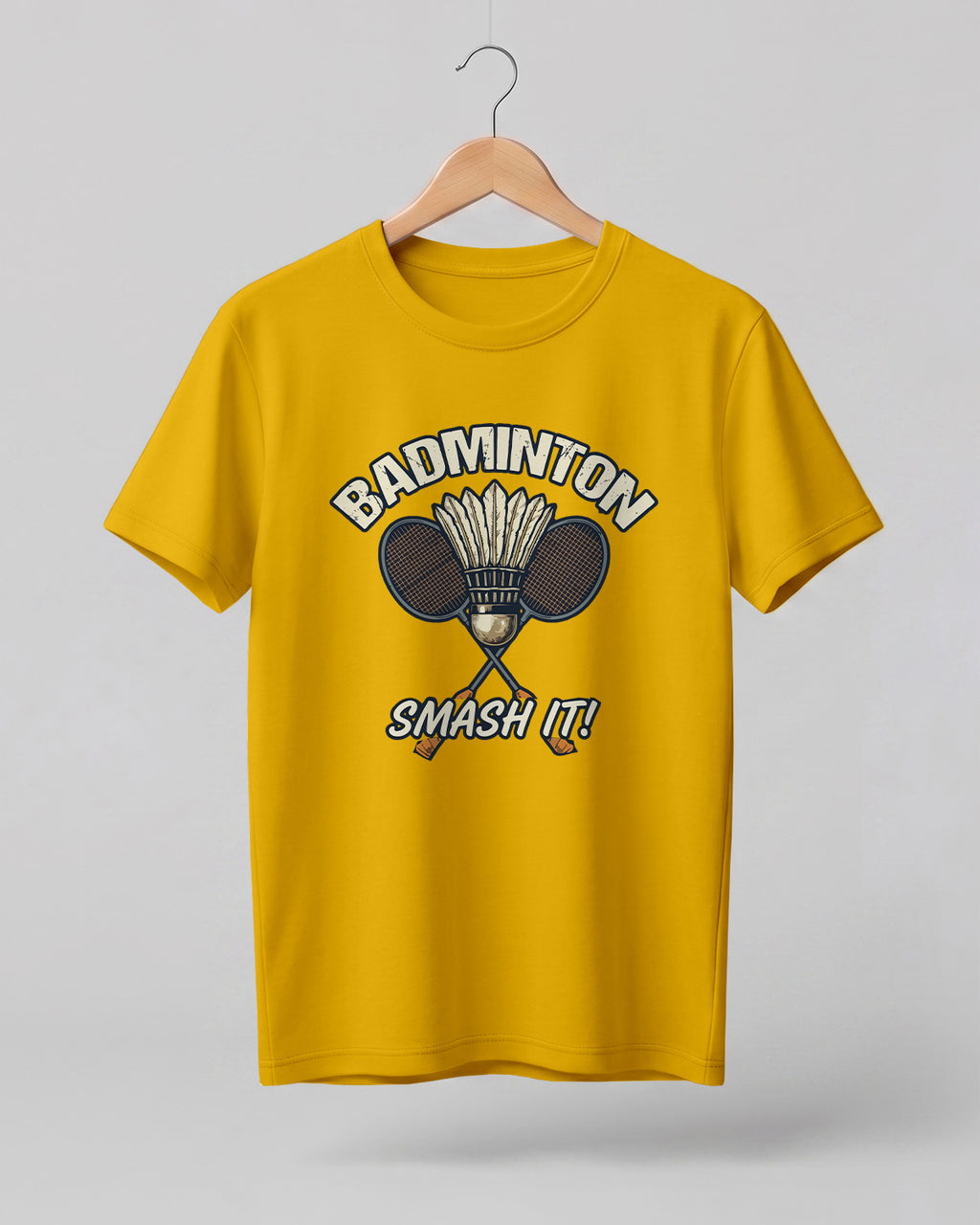 Motivational sports graphic half sleeve t-shirt featuring “Badminton Smash It!” typography with crossed racket and shuttlecock design printed on premium cotton fabric.